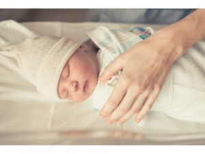 sleeping newborn baby with mother's hand