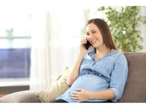 schwangere Leihmutter im Gespräch mit Babys Eltern