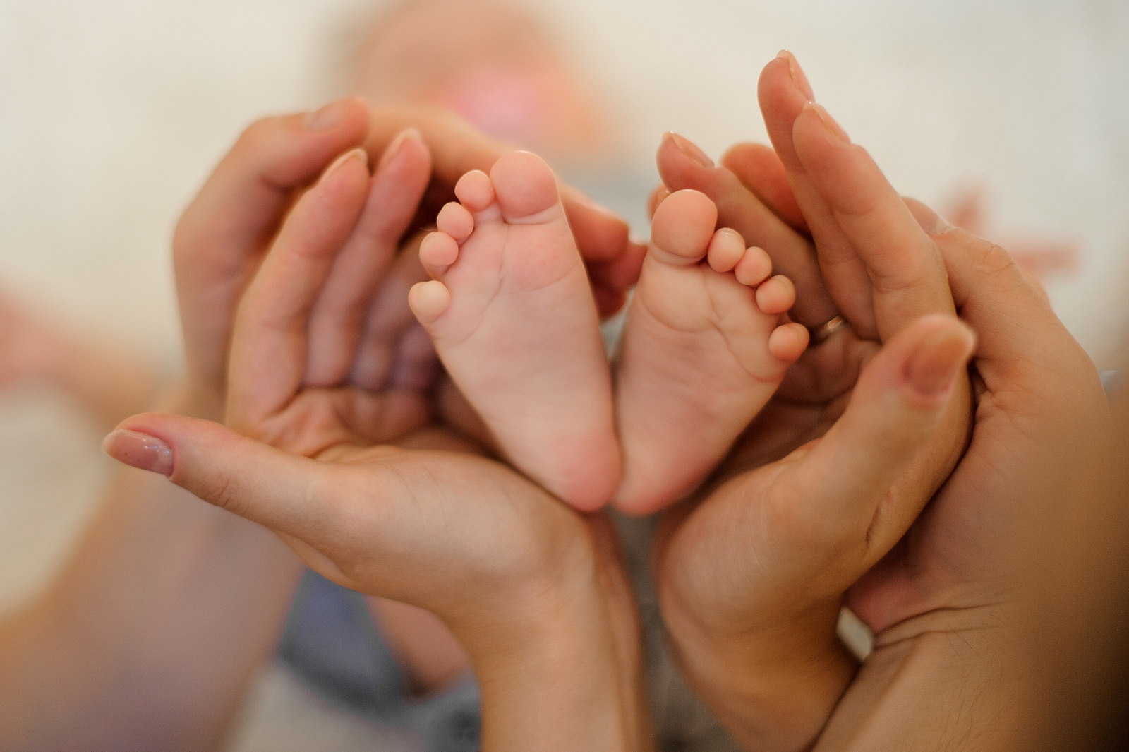 Pies de bebé en manos de los padres