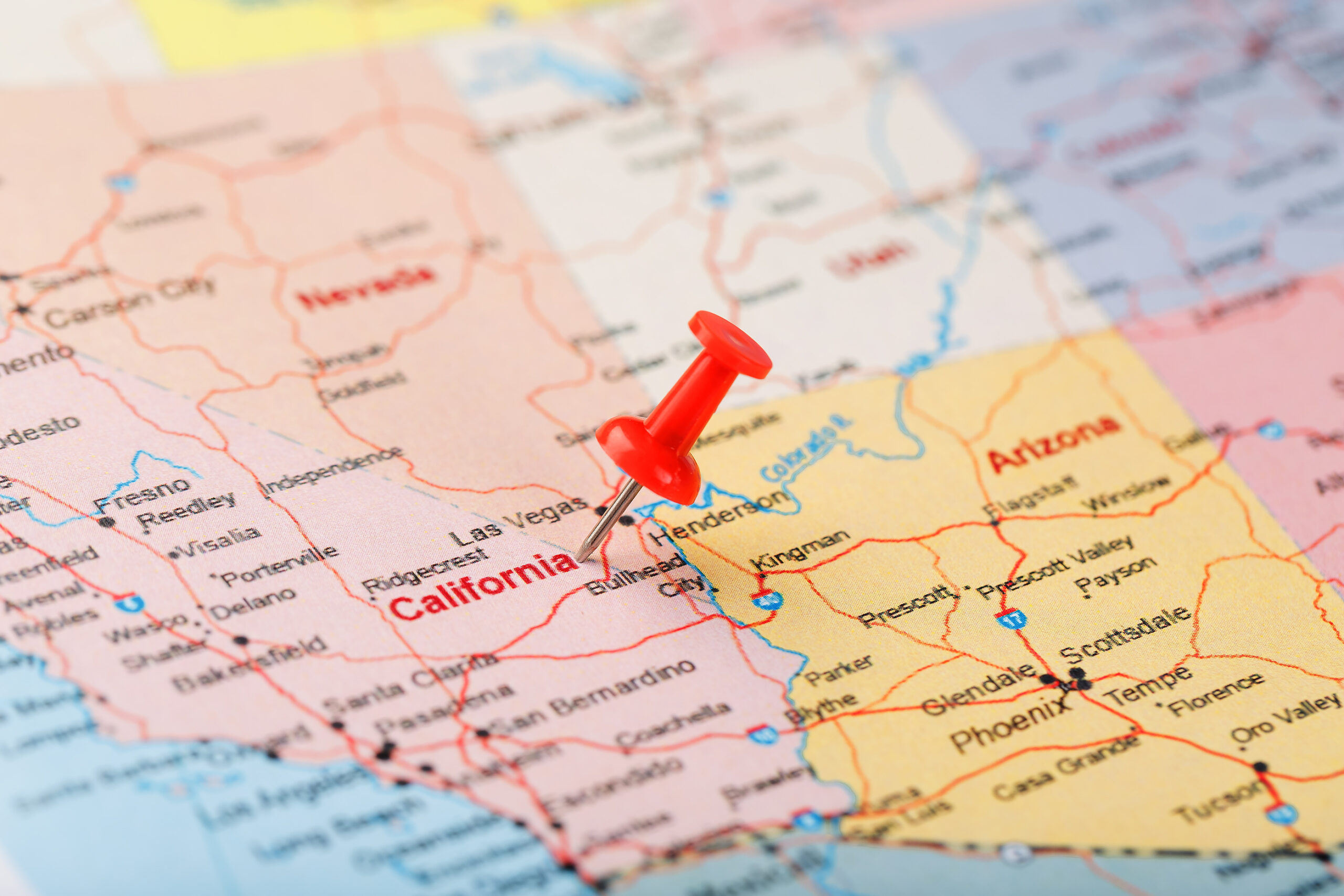 Close de um mapa com um alfinete vermelho marcando um local na Califórnia.