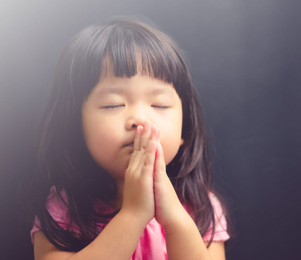 Jong meisje met gesloten ogen bidden of een wens doen.