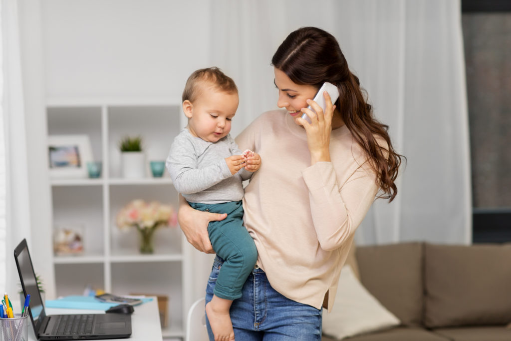 madre con bambino che chiama smartphone a casa