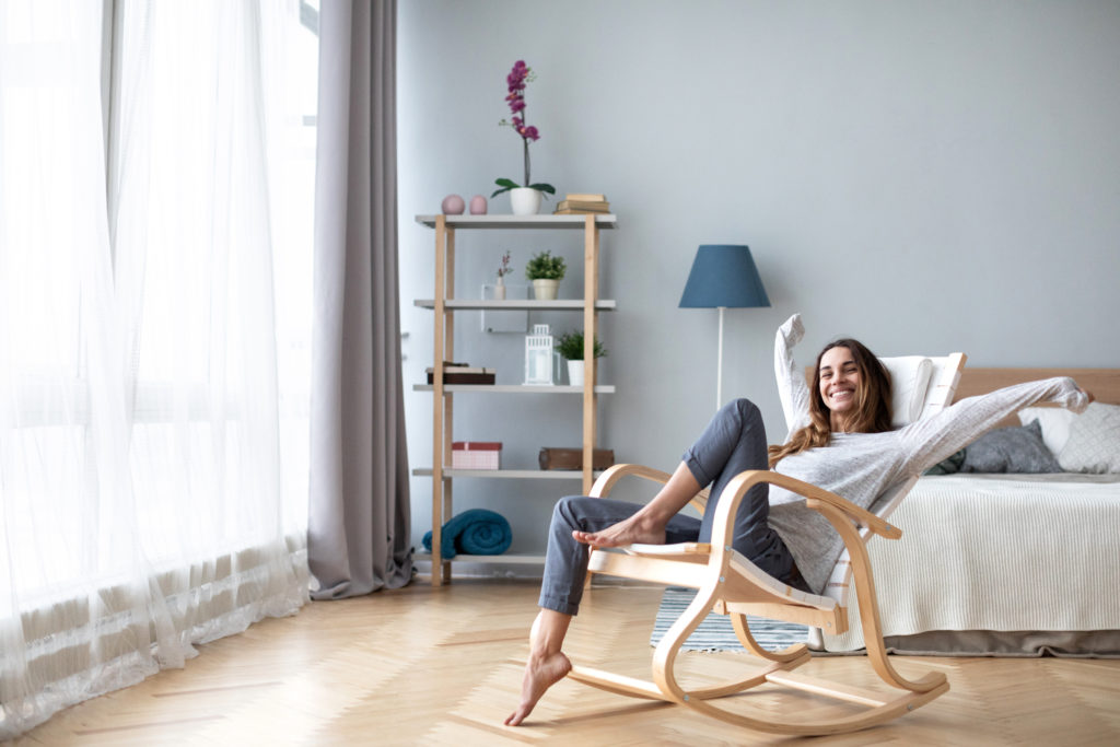 Femme heureuse se reposant confortablement assise sur une chaise moderne