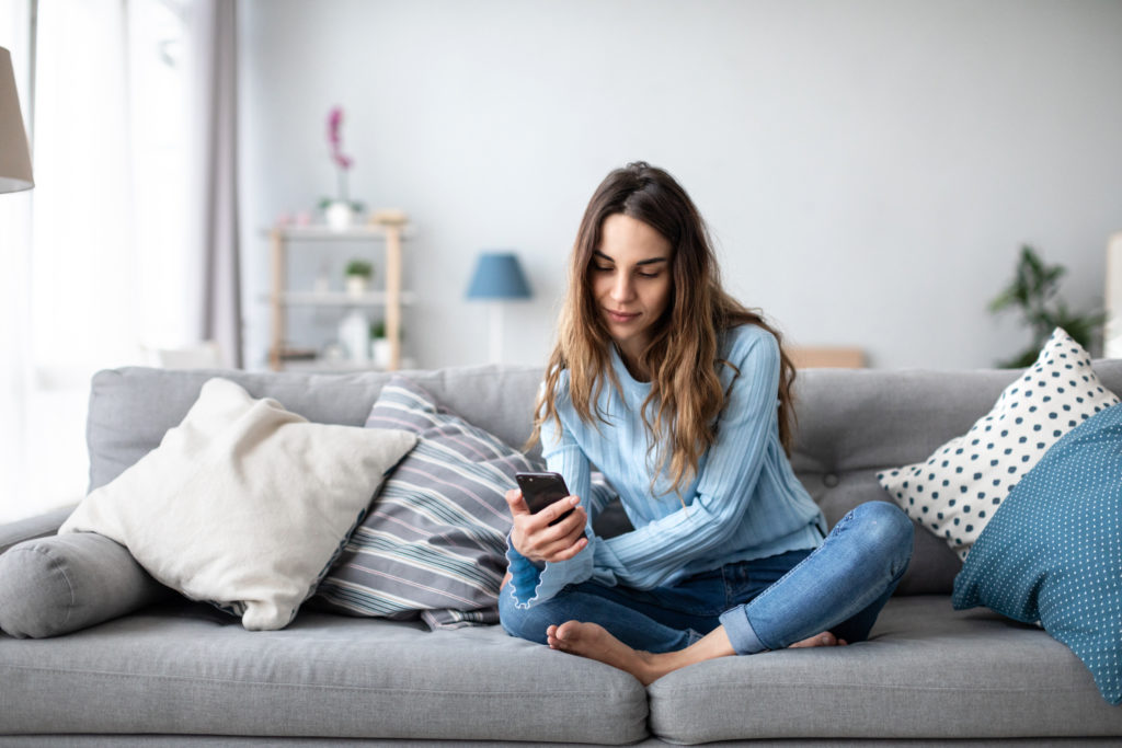 Aantrekkelijke lachende vrouw met behulp van slimme telefoon