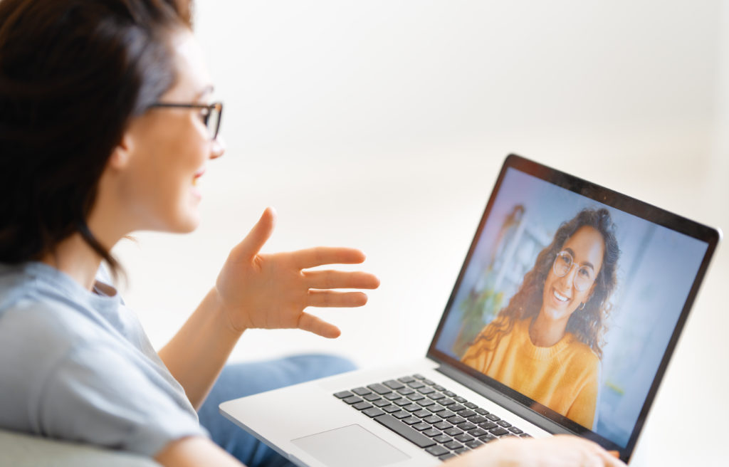 Frau benutzt Laptop für Ferngespräche