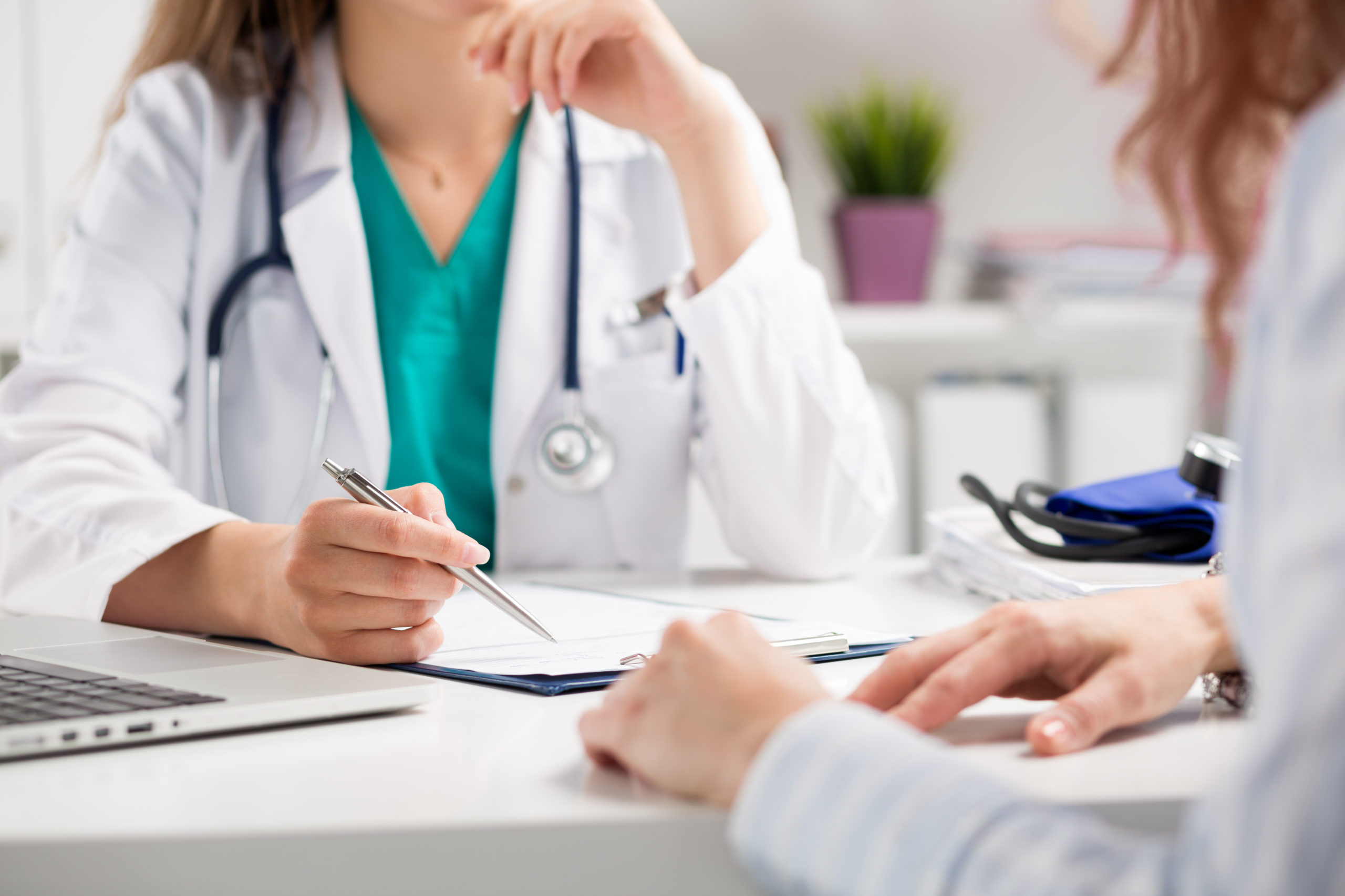 Doctor writing on a clipboard about egg donation consultation.