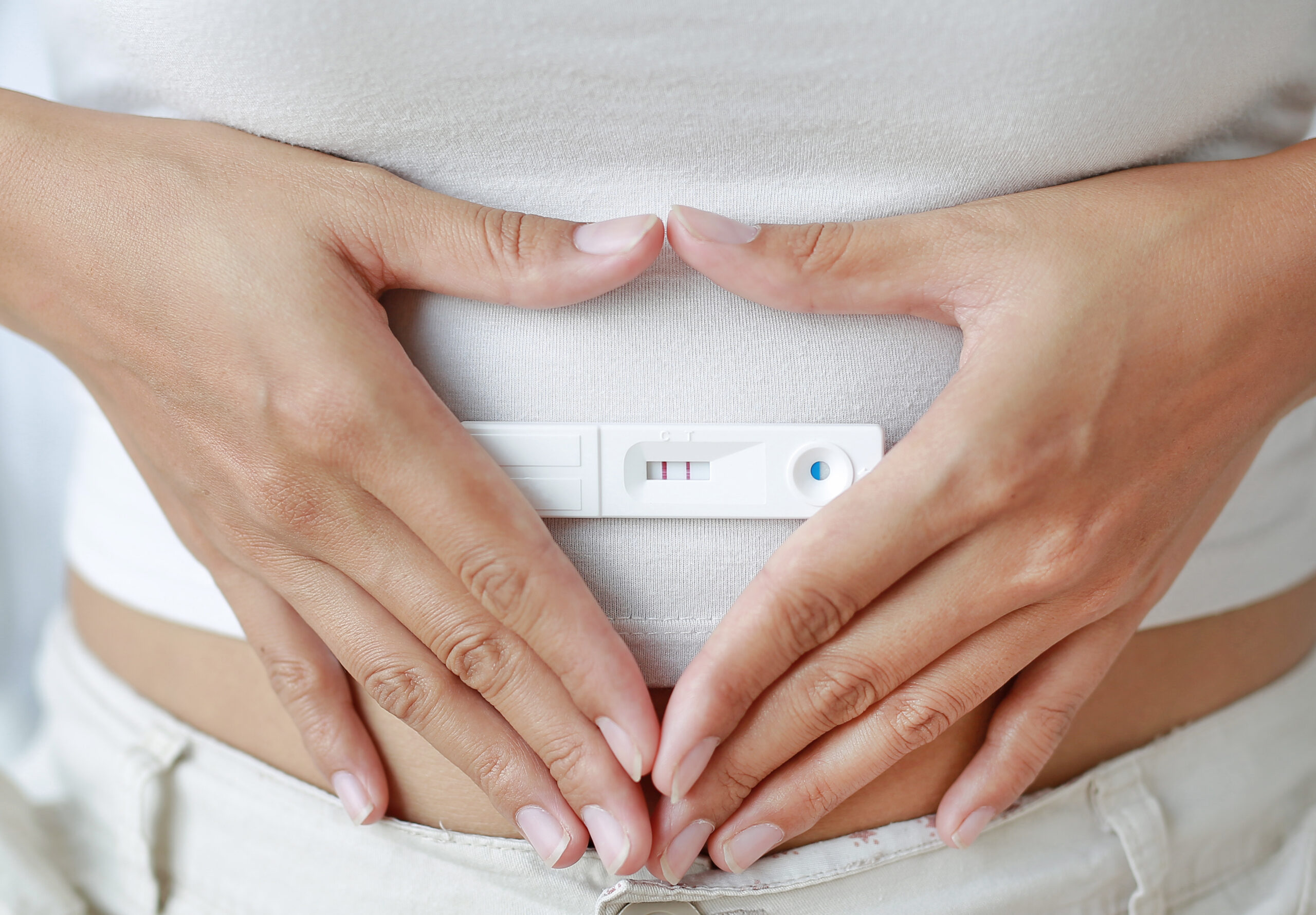 Persoon met een positieve zwangerschapstest.
