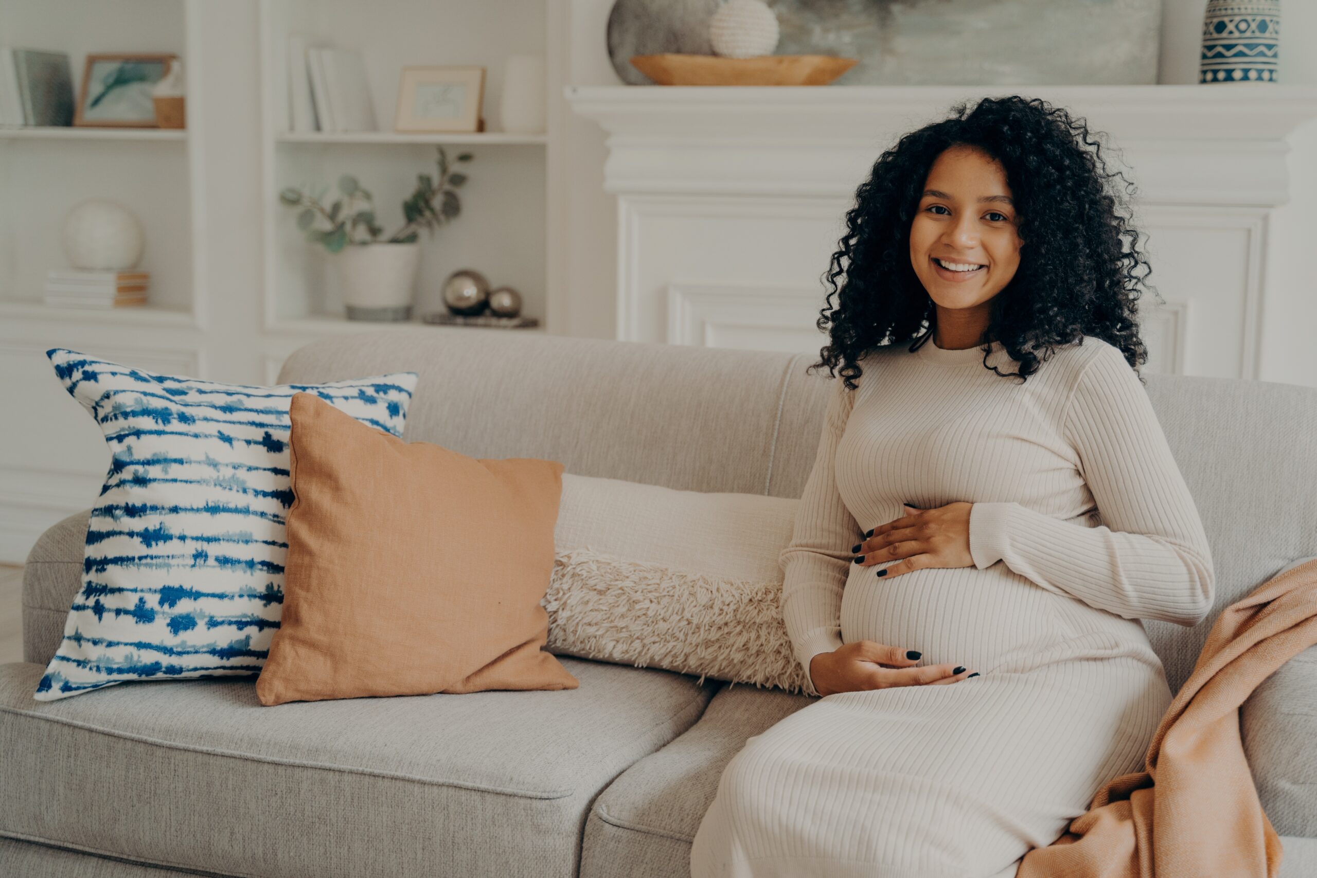 pregnant woman is sitting on the couch
