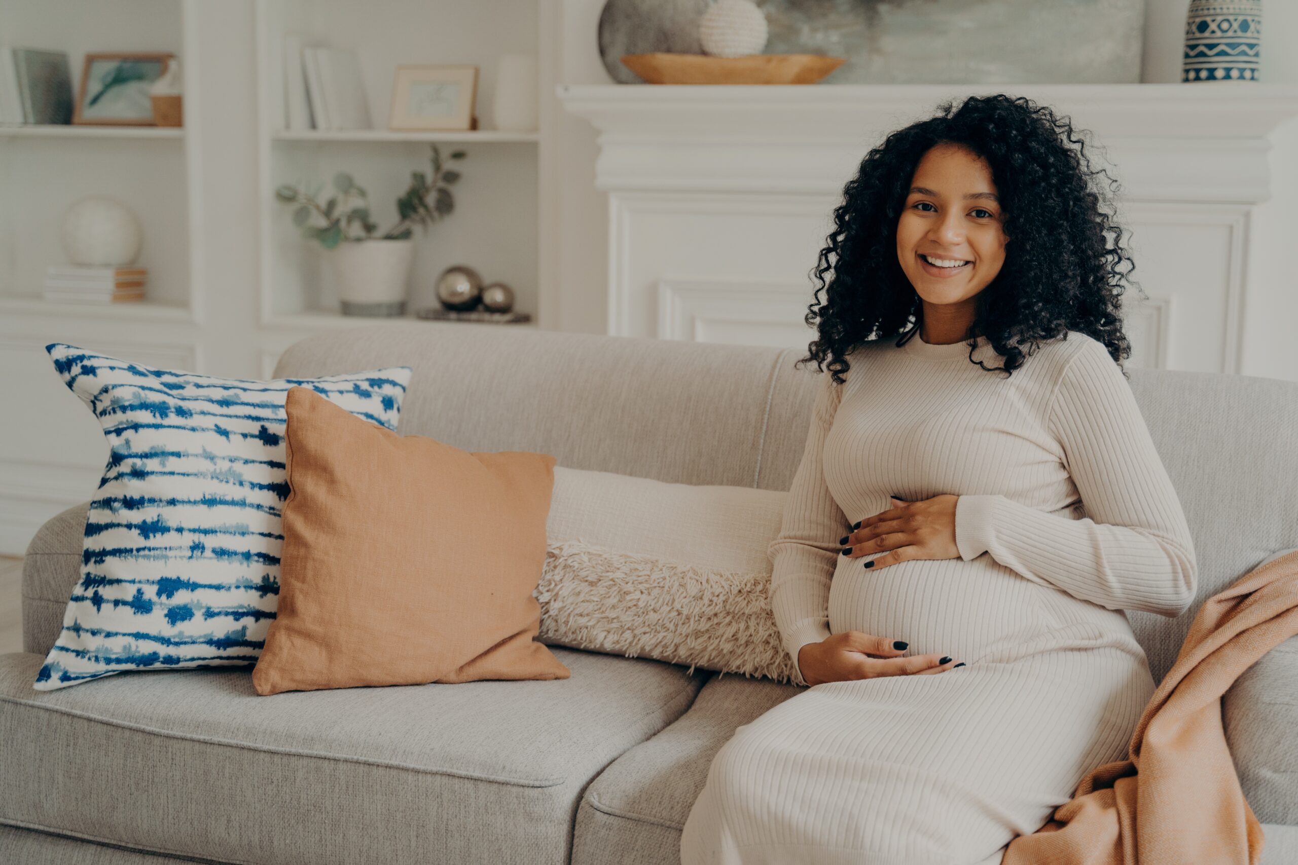 une femme enceinte est assise sur le canapé