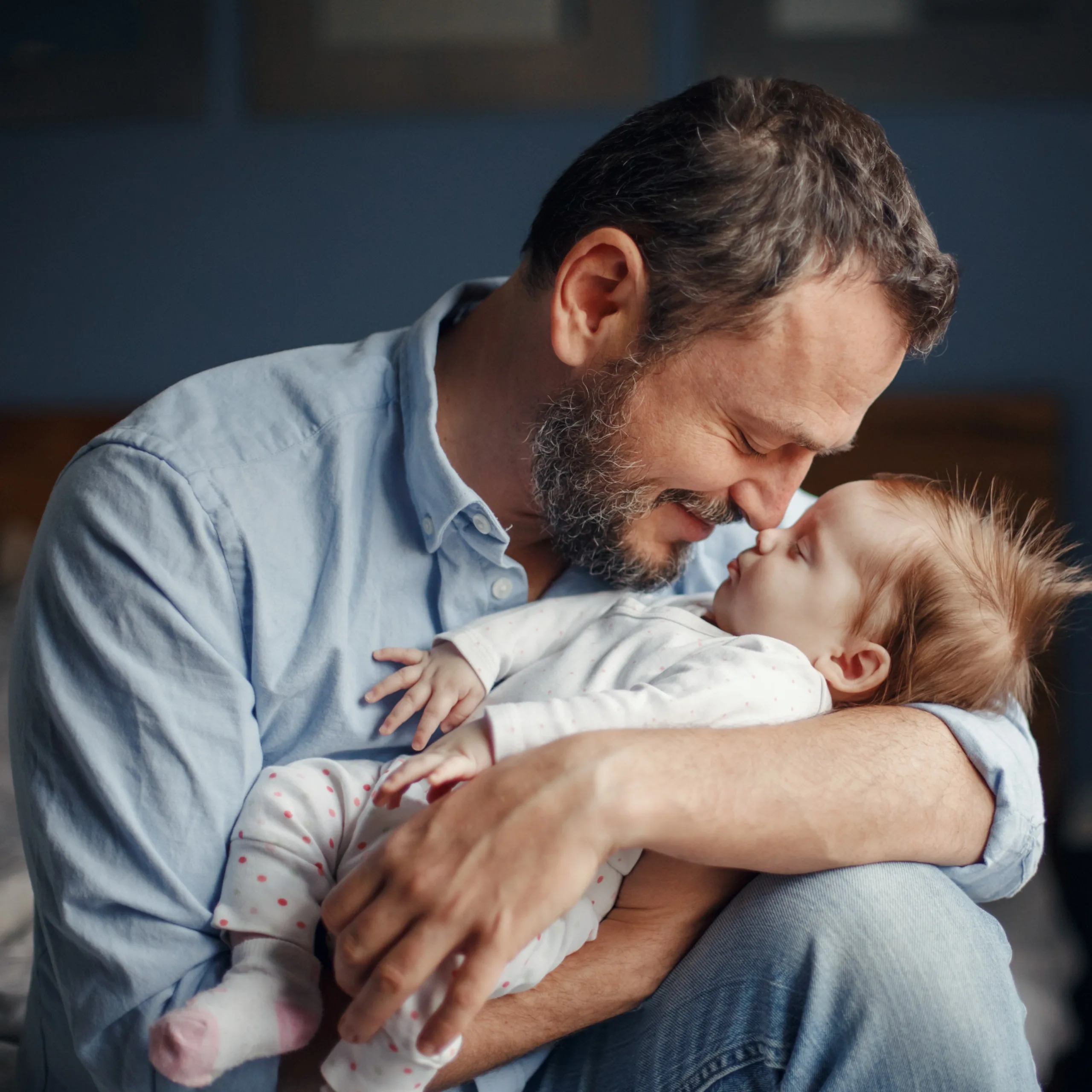Papá alegre sosteniendo a su bebé